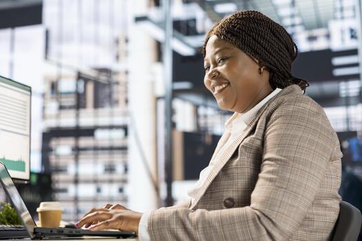 Focused african american general manager multitasking at desk to solve business tasks and operations on computer and documents. Woman meeting deadlines while making strategic decisions. photo
