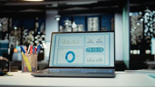 Empty corporate boardroom at night with digital display of performance metrics, graphs and projections on laptop. Modern office in a multinational company reflects business management. photo