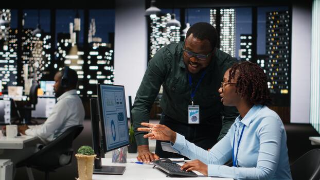 Black company manager and assistant collaborating on a new expansion plan, ensuring a synergy between enterprise goals and performance metrics. Collaborative insights for a project. photo