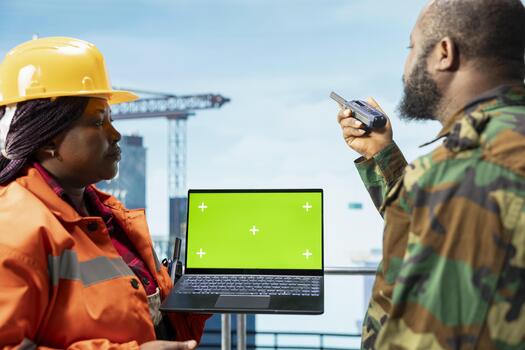 Chroma key laptop used by soldier doing escort duty for offshore rig, monitoring operations. Military unit guards drilling barge against threats, using isolated screen notebook to make security plan photo