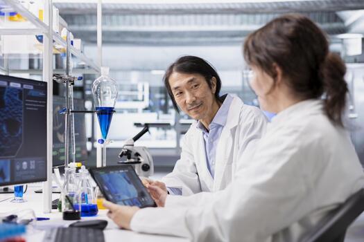 Smiling laboratory scientists using tablet app to process DNA patient data for clinical research. Upbeat lab colleagues use touchscreen device to do lab genetic analysis diagnostics photo