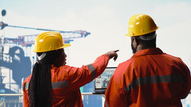 Offshore platform employees use performance management software to observe operations. Crew uses laptop program integrating sensor readings to manage industrial barge operations photo