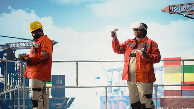 Offshore rig technician monitoring operations using VR goggles, doing maintenance. Drilling rig engineering team reviewing energy operations using virtual reality technology, photo