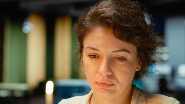 Female manager engaged in writing notes for a presentation on her laptop, extracting essential highlights from finance documents and making a summary for business goals and upcoming tasks. Camera B. photo