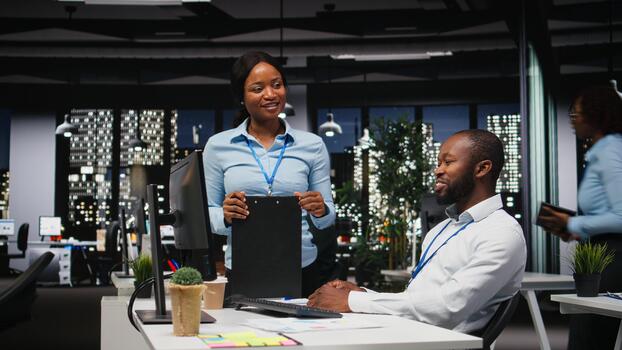 African american staff members engaged in project planning and report writing, using business data to ensure alignment with objectives. Building an agenda for future projects, after hours. photo
