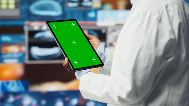 Chroma key tablet used by healthcare expert looking at MRI data analytics. African american scientist in medical lab reading health data with mockup device software, camera B photo