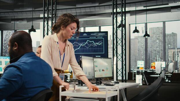 Woman secretary in an office pushes a trolley filled with paperwork and reports, bringing files to a colleague and ensuring efficient distribution of resources. Administrative tasks. photo