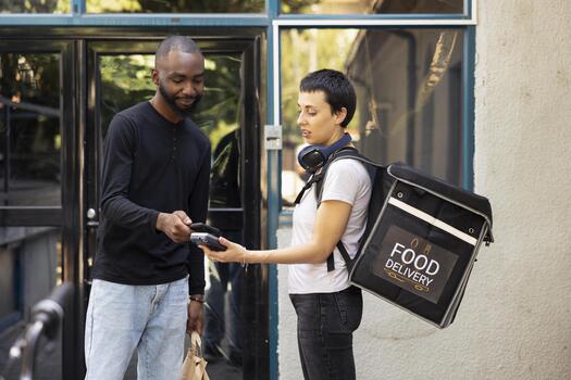 mensajero entrega para llevar bolso como cliente paga utilizando un inalámbrico pago Terminal. hombre utilizando nfc móvil pago sistema para un sin costura y moderno experiencia para rápido comida entrega. foto
