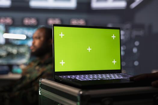Officer in command post gathering information on enemy troops using mockup laptop. Intelligence corps unit doing assessment of adversaries vulnerabilities with chroma key notebook photo