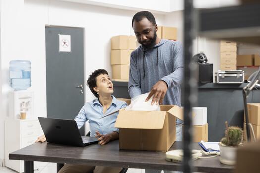 Workers solving local small business shipment tasks by packing goods and reviewing custom order logistics, ensuring express delivery with in house hand packing. Distribution center. photo