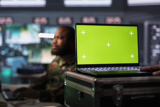 Army telecommunication systems agent using radio and satellite tech, providing combat support using green screen laptop. Man managing military communications networks with chroma key notebook photo