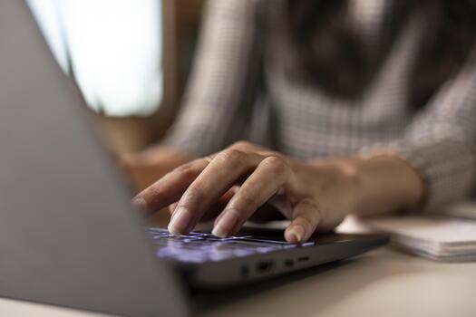 Closeup on female hands typing on laptop keyboard, updating business reports and analyzing financial data. Woman entrepreneur working remotely from home office workspace, editing project presentations photo