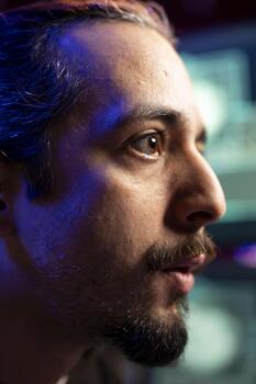 Close up of rogue technician looking at screen, using AI to evade security with stealth virus. Hacker in base of operation using deep learning tech to hide malicious exploit from cybersecurity photo