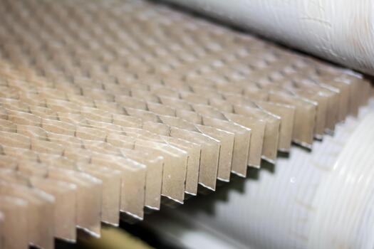 Detailed view of the continuous industrial manufacturing process shaping corrugated paper into a geometric honeycomb structure, showcasing precision and efficiency in modern production lines photo
