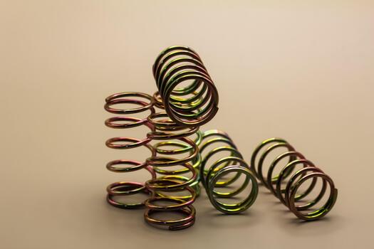 Vibrant, multi-colored metal helical springs, artfully arranged, illustrate essential mechanical components with elastic properties and a unique iridescent finish for engineering uses photo