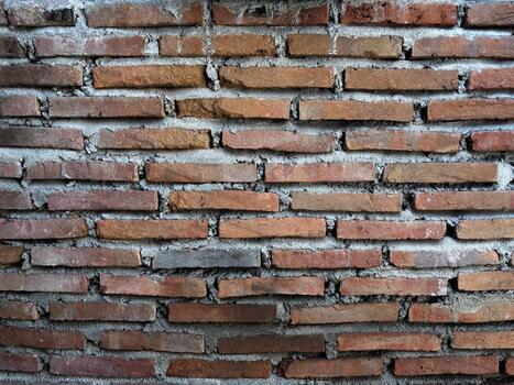 Full-frame abstract texture of an ancient, rough brick wall with thick mortar lines, perfect for architectural design themes photo
