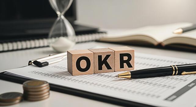 Wooden blocks displaying OKR on financial report in a bright office setting symbolizing objectives and key results for business strategy time management and goal achievement with a sense of focus and photo