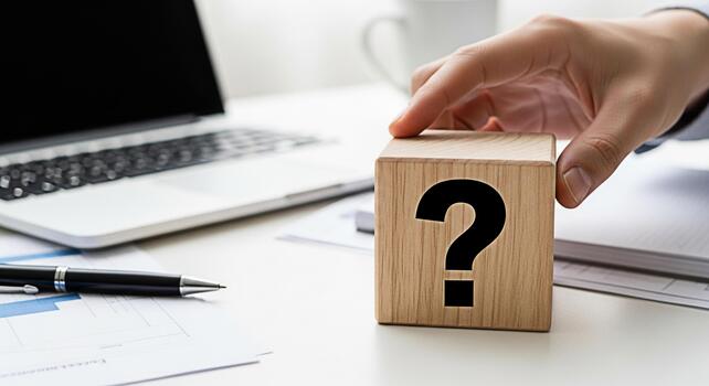 Hand placing a wooden block with a question mark on a bright office desk symbolizing uncertainty and the need for solutions in business and decisionmaking processes photo