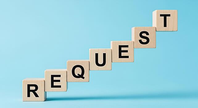 Wooden blocks spelling REQUEST arranged in a staircase pattern against a light blue background symbolizing demand and the process of asking for something conveying a sense of anticipation and expectat photo