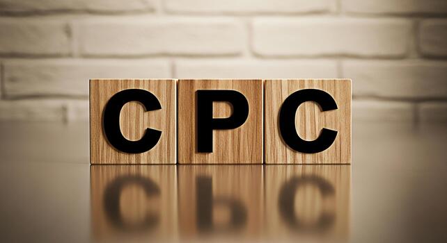 Wooden blocks displaying CPC on a reflective surface against a brick wall representing cost per click advertising strategy conveying a message of marketing efficiency and online business investment photo