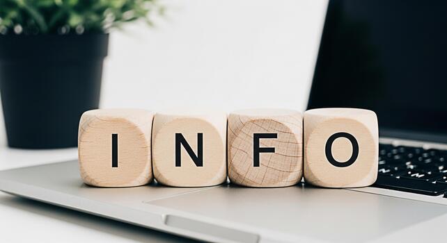 Wooden blocks spelling INFO resting on a laptop in a bright office setting conveying a message of knowledge data and information access in the digital age for business and education photo