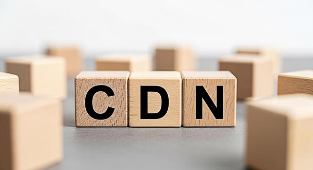Wooden blocks displaying CDN on a gray surface representing content delivery network technology and its importance for fast website loading and improved user experience in a modern digital environment photo