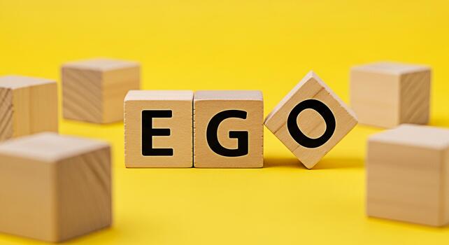 Wooden blocks spelling EGO on a bright yellow background representing selfimportance and inflated selfesteem highlighting the concept of ego and its impact on personal growth and interpersonal relatio photo
