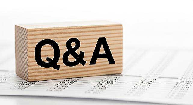 Wooden block displaying QA resting on a financial spreadsheet symbolizing questions and answers in business finance and accounting creating a clear and concise visual representation of information photo