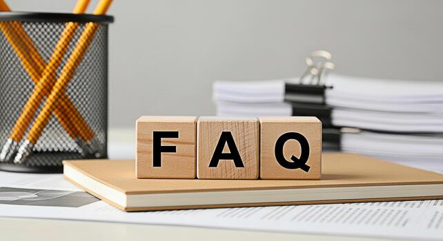 Wooden blocks displaying FAQ on a notebook in a bright office setting representing frequently asked questions and information resources for customer support and business assistance photo