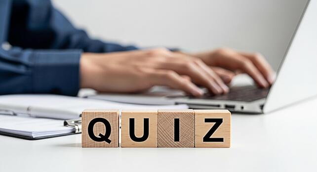 Person taking an online quiz on a laptop in a bright office setting emphasizing education and assessment with wooden blocks spelling out QUIZ in the foreground creating a focused and intellectual atmo photo