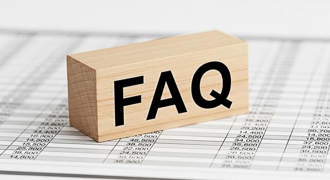 Wooden block displaying FAQ on a financial spreadsheet representing frequently asked questions in business providing clarity and information and fostering a sense of understanding and support photo