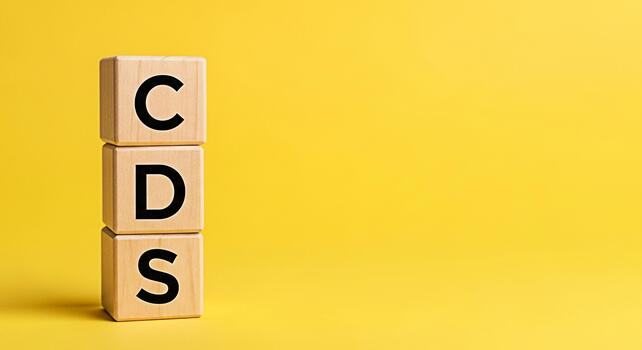 Wooden blocks displaying CDS on a vibrant yellow background representing credit default swaps and financial instruments symbolizing risk management and investment strategies in a modern financial cont photo
