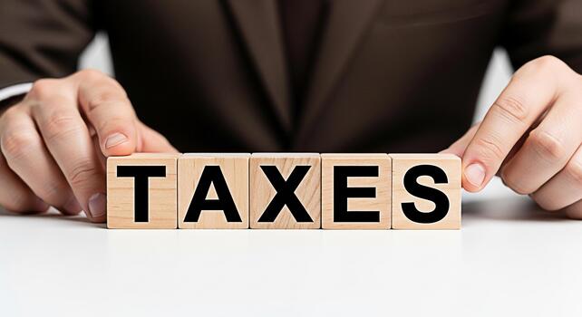 hombre en traje arreglando de madera bloques ortografía impuestos en un blanco mesa simbolizando financiero planificación y responsabilidad en un limpiar profesional ajuste transporte un sentido de orden y controlar foto