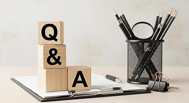 Wooden blocks displaying Q A on a bright desk with pencils and a clipboard representing knowledge and information in a professional learning environment fostering curiosity and understanding photo