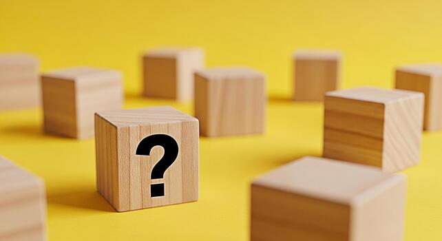 Wooden blocks displaying a question mark on a vibrant yellow surface symbolizing uncertainty and the search for answers in a playful and engaging setting ideal for educational or problemsolving concep photo