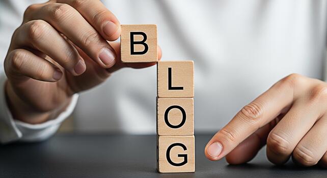 Person stacking wooden blocks spelling BLOG on a dark surface symbolizing content creation and online communication conveying a message of sharing ideas and information through blogging photo
