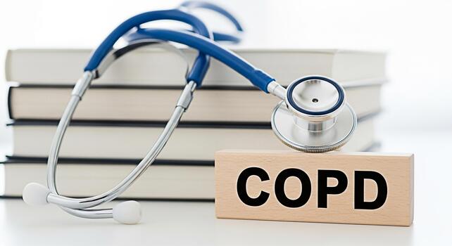 Stethoscope resting on a wooden block with COPD text placed in front of a stack of books on a white surface representing medical research and awareness for Chronic Obstructive Pulmonary Disease photo
