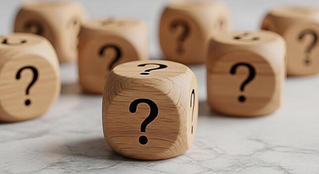 Wooden dice displaying question marks on a textured surface symbolizing uncertainty and the need for answers in a complex and inquisitive environment representing a conceptual challenge photo