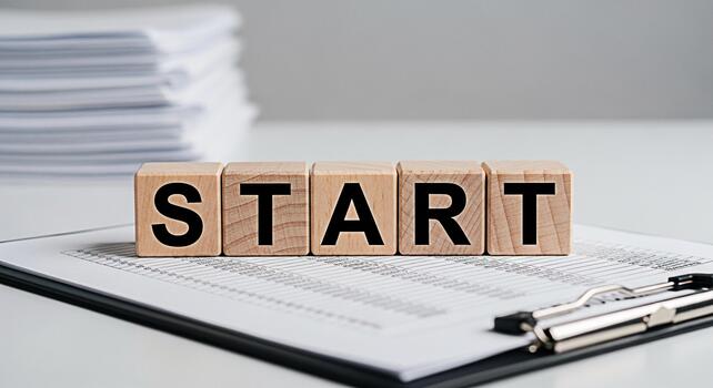 Wooden blocks spelling START resting on a clipboard with financial data in a bright clean office environment symbolizing new beginnings and business opportunities with a sense of optimism and forward photo