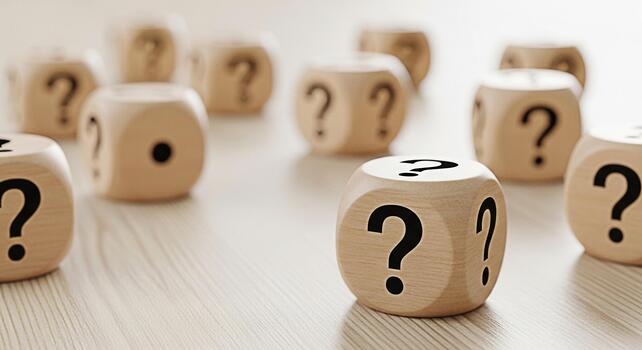 Wooden dice displaying question marks scattered on a bright wooden surface symbolizing uncertainty and the need for answers in a complex and inquisitive environment creating a sense of mystery photo