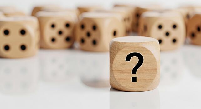 Wooden dice with a question mark standing out among other dice on a reflective surface symbolizing uncertainty choice and the need for decisionmaking in a complex and ambiguous situation photo