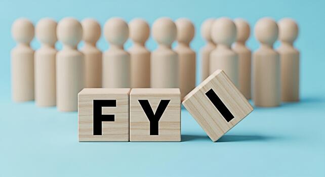 Wooden figures standing behind blocks displaying FYI on a blue background representing information sharing and transparency in a corporate setting conveying a message of awareness and important update photo