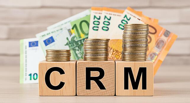 Stacks of coins resting on wooden blocks spelling CRM with euro banknotes in the background symbolizing customer relationship management and financial growth in a business setting conveying success photo