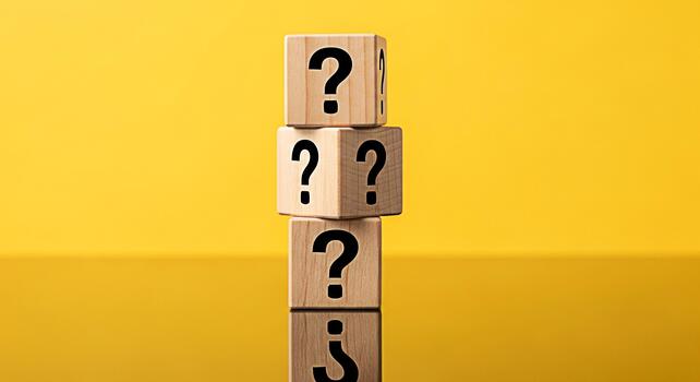 Stacked wooden blocks displaying question marks against a vibrant yellow backdrop symbolizing uncertainty and the search for answers in a bright and inquisitive environment photo