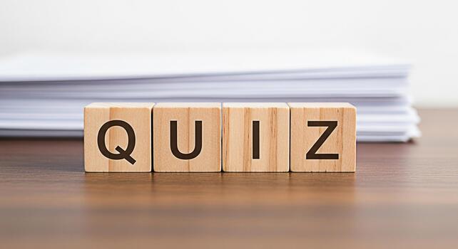 Wooden blocks spelling QUIZ on a wooden table with a stack of papers in the background representing knowledge testing and assessment in an educational setting conveying a sense of challenge and learni photo