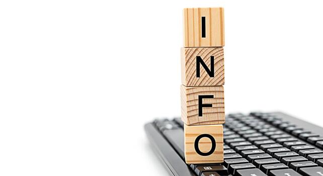 Wooden blocks spelling INFO resting on a black computer keyboard against a white background symbolizing information knowledge and access to data in the digital age conveying a clean and modern aesthet photo