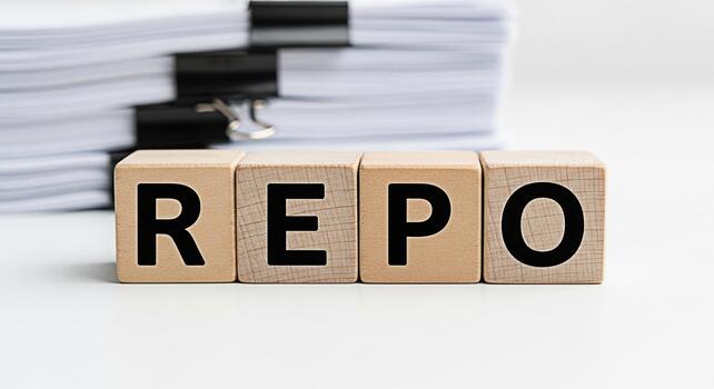 Wooden blocks spelling REPO sitting on a white desk in front of a stack of documents representing repurchase agreements and financial transactions in a clean and organized environment photo
