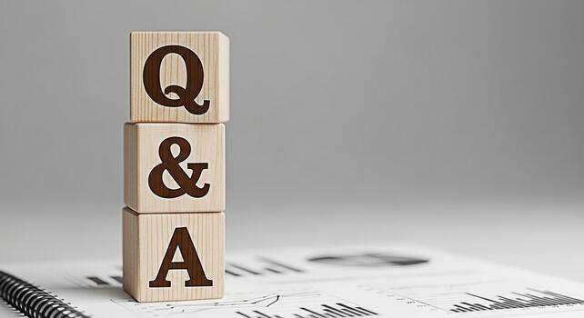 Wooden blocks displaying QA stacked on a financial report in a bright studio setting representing knowledge sharing problemsolving and informed decisionmaking for business growth and success photo