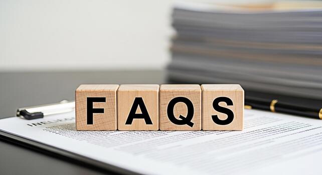 Wooden blocks spelling FAQs on a document in a bright office setting representing frequently asked questions and information accessibility for customer support and business transparency photo