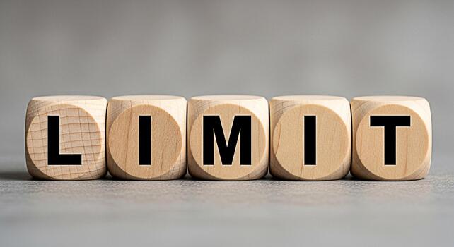 Wooden blocks spelling out LIMIT on a neutral surface representing boundaries and restrictions evoking a sense of control and awareness of constraints in business and personal life photo